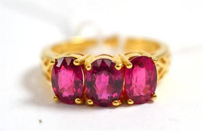 Lot 119 - An 18ct gold red three stone 'majestic ruby' ring