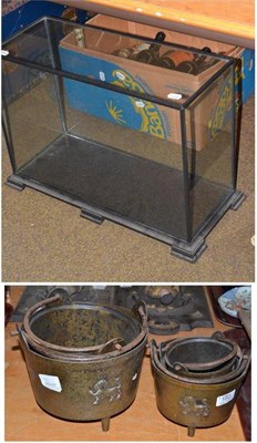 Lot 182 - A graduated set of five brass smelting type pans cast with lions and a glazed display case