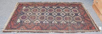 Lot 1115 - A Baluch Rug, the indigo field with two...