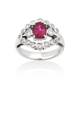 Lot 2006 - A Ruby and Diamond Cluster Ring the oval cut...
