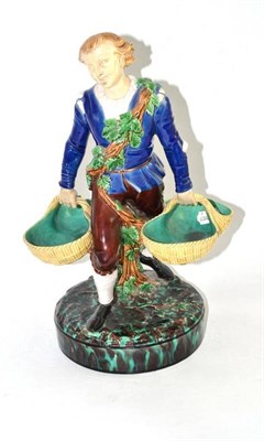 Lot 208 - A Victorian majolica centrepiece as a man carrying two grape baskets (a.f.)