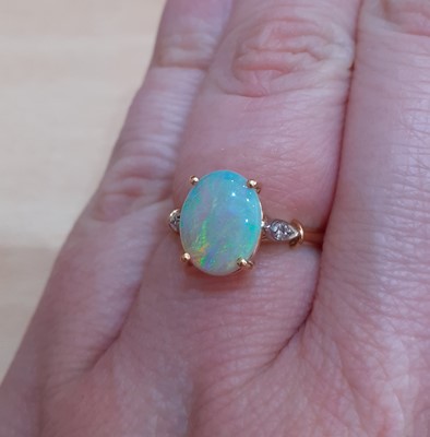 Lot 2150 - An Opal and Diamond Ring the oval cabochon...