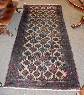 Lot 1104 - A Baluch Rug, the camel ground with a lattice...