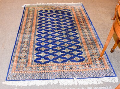 Lot 1110 - A Bukhara Rug, the indigo field with columns...