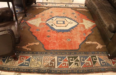 Lot 1326 - A Turkish Wool Rug, the salmon pink field with...