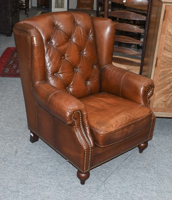 Lot 1165 - A Buttoned Brown Leather Wingchair, with...