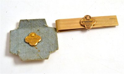 Lot 403 - A tie clip and small lapel badge ";Sterling Drug Inc."; stamped 'Balfour 10k'