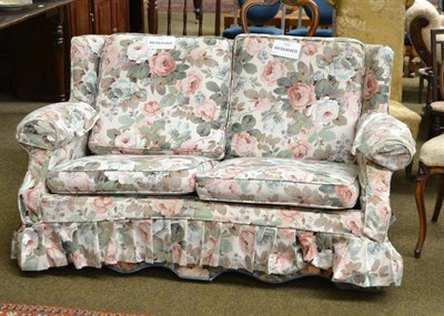 Lot 598 - A small two seater settee with loose floral covers