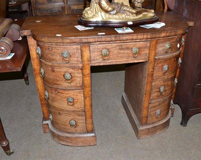 Lot 612 - A Regency mahogany break bowfront small sideboard with brass lion mask and ring handles