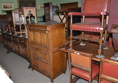 Lot 621 - An oak composite dining suite comprising trestle table, five leather upholstered chairs, drinks...