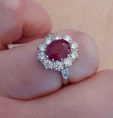 Lot 2009 - A Ruby and Diamond Cluster Ring the oval cut...
