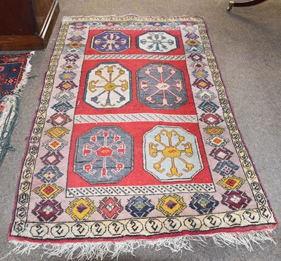 Lot 1104 - An Anatolian Rug, the crimson field with six...