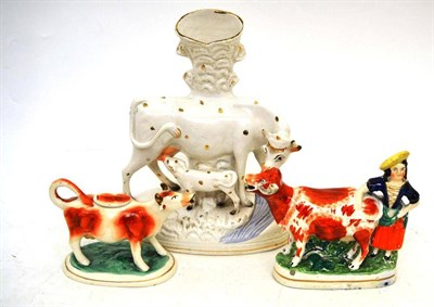 Lot 42 - Staffordshire cow and calf spill vase, Staffordshire cow and milkmaid and a cow milk jug (3)