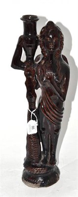 Lot 86 - A Treacle Glazed Pottery Figural Candlestick, 19th century, as an angel standing holding an...