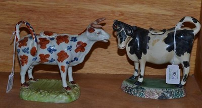 Lot 92 - A Pearlware Pottery Cow Creamer, early 19th century, the standing beast with patterned coat in...