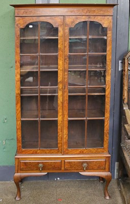 Lot 1210 - A Reproduction Burr Walnut Bookcase, with two...