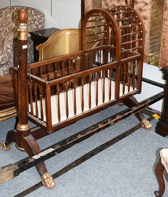 Lot 1280 - An Empire Style Parcel-Gilt Mahogany Cradle,...