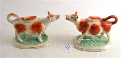 Lot 313 - Pair of cow creamers with lids