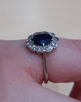 Lot 2102 - A Sapphire and Diamond Cluster Ring the oval...