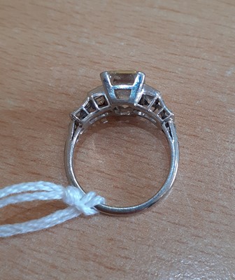 Lot 2320 - A Diamond Ring the central emerald-cut diamond...