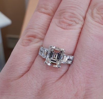 Lot 2320 - A Diamond Ring the central emerald-cut diamond...