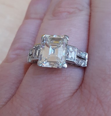 Lot 2320 - A Diamond Ring the central emerald-cut diamond...