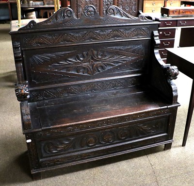 Lot 1212 - An Early 20th Century Carved Oak Box Settle,...