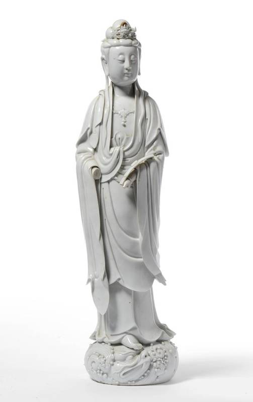 Lot 141 - A Chinese Blanc de Chine Porcelain Figure of Guanyin, 17th/18th century, standing wearing a...
