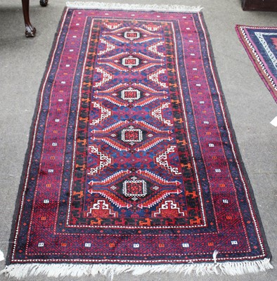 Lot 1016 - A Baluch Rug, the indigo field with four...