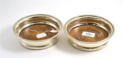 Lot 106 - A pair of George III silver bottle coasters, maker's mark worn, London 1808, plain circular...