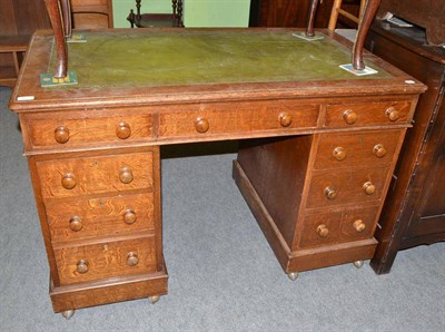 Lot 482 - An Edwardian oak pedestal desk with green leather top