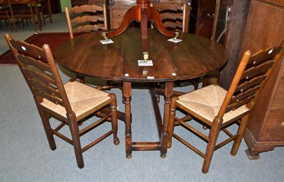 Lot 499 - Oak drop leaf table and a set of four ladder-back rush-seated chairs