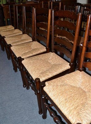 Lot 525 - A set of six rush seated ladder back dining chairs