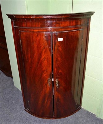 Lot 561 - A 19th century mahogany bow fronted wall hanging corner cupboard