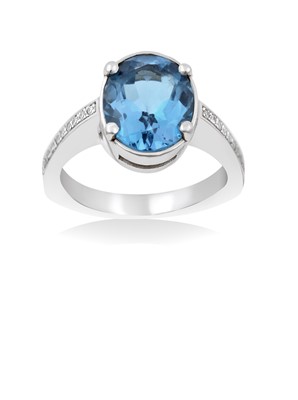 Lot 2020 - A Blue Topaz and Diamond Ring the oval cut...