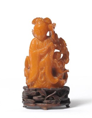Lot 210 - A Chinese Amber Figure of Guanyin, late 18th/early 19th century, standing holding a fly whisk...