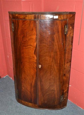 Lot 702 - Georgian bow front hanging corner cupboard