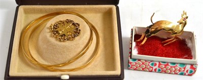 Lot 107 - A pair of yellow metal bangles, springbok brooch and a Maltese cross pendant