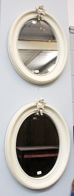 Lot 1139 - A Pair of Cream Oval Mirrors, surmounted...