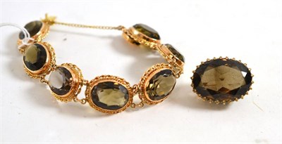 Lot 144 - A smokey quartz bracelet and a smokey quartz brooch