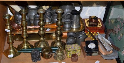 Lot 231 - A shelf of ornamental items and metalware including brass and copper trays, a brass hotplate, brass