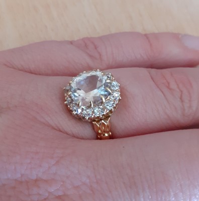 Lot 2040 - A Topaz and Diamond Ring the oval cut light...