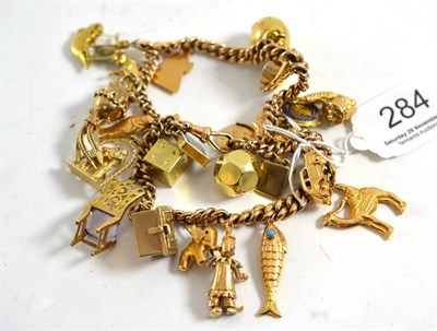 Lot 284 - A charm bracelet hung with twenty four assorted charms