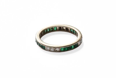 Lot 26 - An Emerald and Diamond Eternity Ring, trios of...