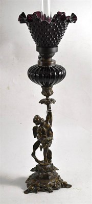 Lot 325 - A bronzed metal cherubic oil lamp with amethyst glass reservoir and shade