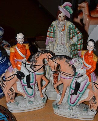 Lot 334 - Pair of Staffordshire equestrian figures and a highlander figure