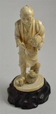 Lot 339 - A Japanese elephant ivory figure of a peasant and cockerel, circa 1910