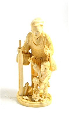 Lot 341 - A Japanese elephant ivory figure of a peasant, child and octopus, circa 1910