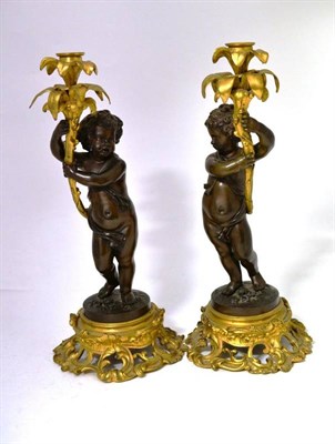 Lot 257 - A Pair of Parcel Gilt Bronze Figural Candlesticks, 19th century, each as a semi-nude cupid...