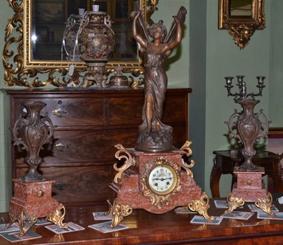 Lot 450 - A French rouge marble clock garniture with bronze spelter figural and vase mount